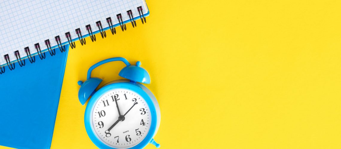 blue-alarm-clock-notepads-yellow-background-flat-design (1) (1)